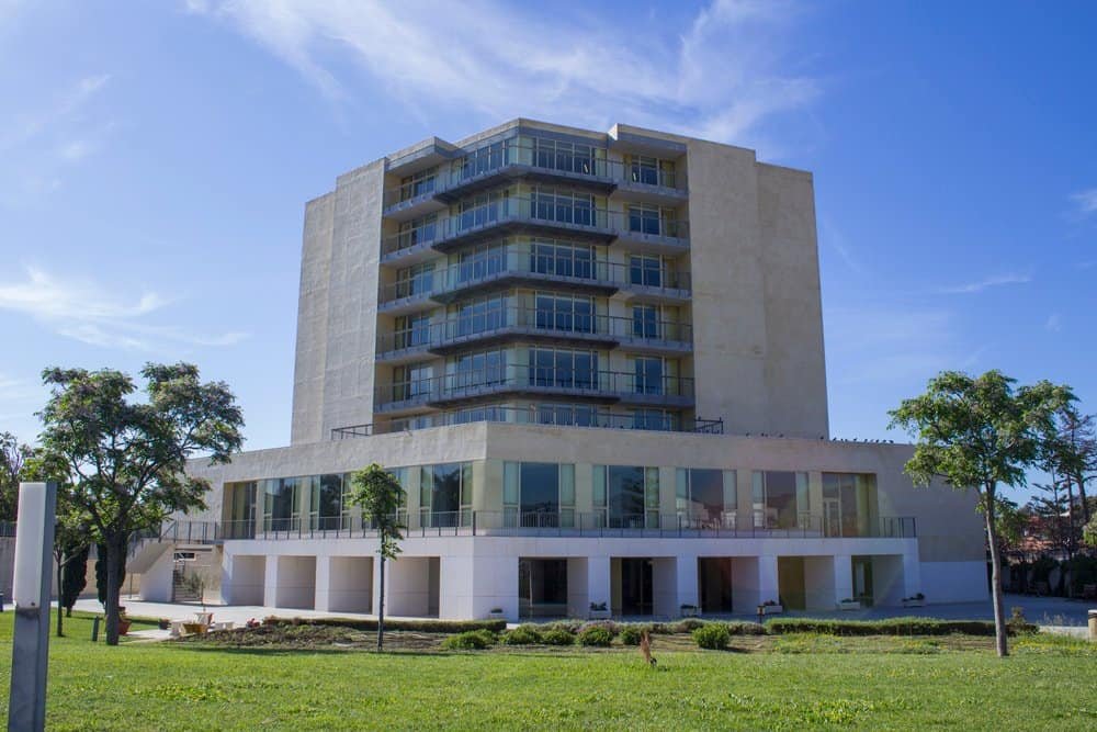 Fachada moderna del centro residencial Vitalia Home en Estepona, edificio amplio con grandes ventanales y rodeado de zonas verdes.