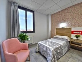 Terapia de rehabilitación en la piscina interior de la residencia, donde un grupo de residentes es asistido por el personal.