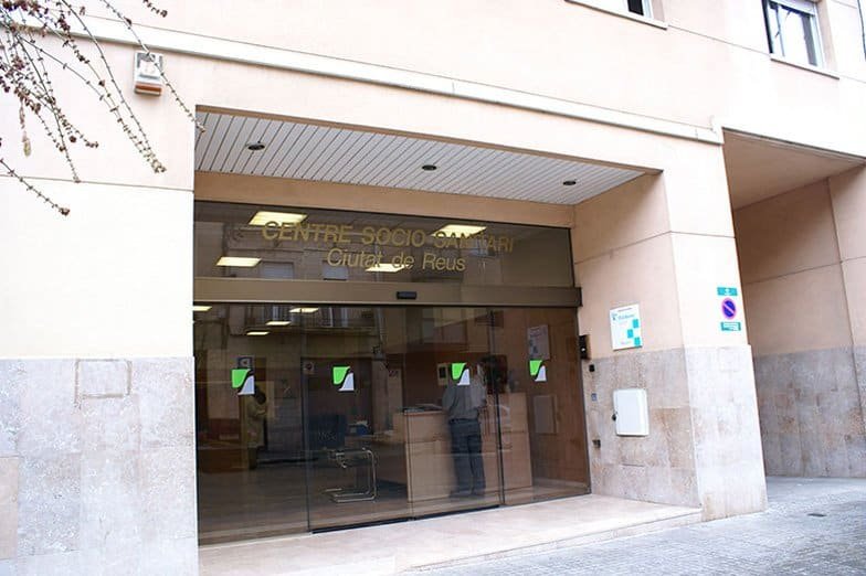 Entrada principal del Centro Socio-Sanitario Colisée Ciutat de Reus, con puertas de cristal y el nombre del centro en la fachada.