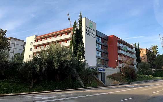 Exterior de un edificio moderno con balcones y un gran letrero de "Ronda de Dalt Residencia Gent Gran" en la fachada.