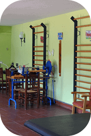 Sala de fisioterapia equipada con espalderas, mesas de trabajo y materiales rehabilitadores.