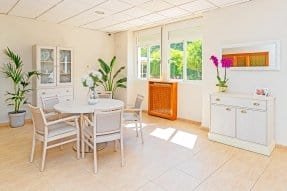 ala de estar o comedor con mesa redonda y sillas en la residencia. El espacio es luminoso y tiene decoración acogedora.