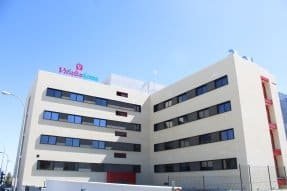 Edificio de varias plantas de color beige, con ventanas azules y el letrero "Vitalia Home".