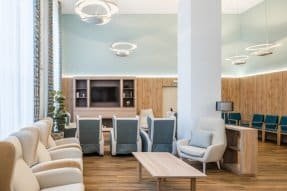 Sala de estar con sillones beige y reclinables, un televisor y una decoración moderna con toques de madera.